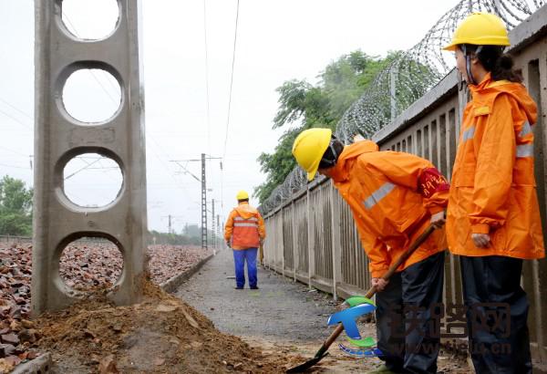 图二为：7月22日，郑州供电段职工雨中巡视接触网供电设备，并对新立供电支柱进行培土加固，确保供电安全稳定。.jpg