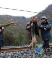 七旬老汉铁路边砍柴危险 联防队员发现帮助抬柴搀扶过铁路